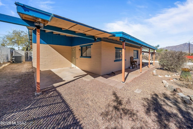 rear view of property with a mountain view, a patio, and central air condition unit