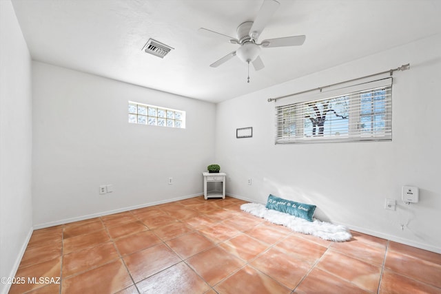 tiled empty room featuring ceiling fan