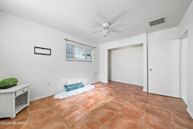 interior space with ceiling fan, tile patterned flooring, and a closet