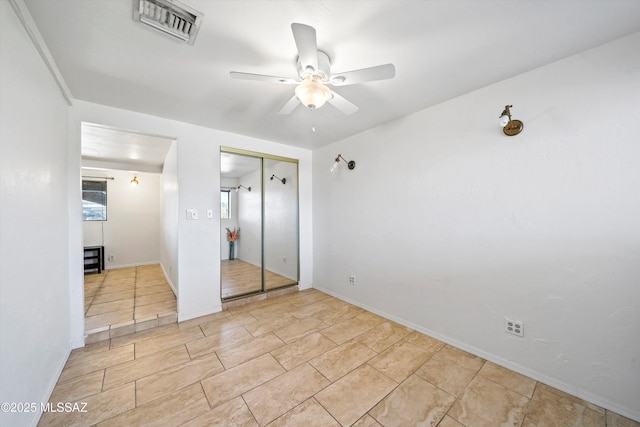 unfurnished bedroom featuring ceiling fan, a closet, and light tile patterned floors