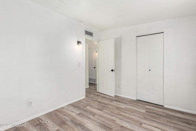 unfurnished bedroom with light hardwood / wood-style floors and a closet