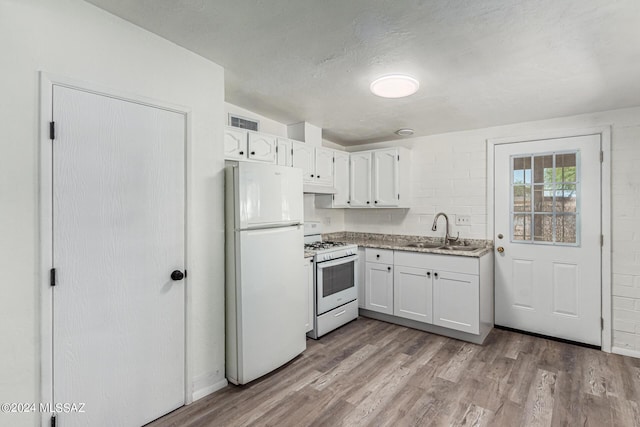 kitchen with white appliances, light hardwood / wood-style floors, sink, and white cabinets