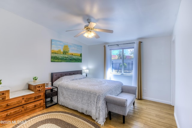 bedroom with ceiling fan, lofted ceiling, and light wood-type flooring