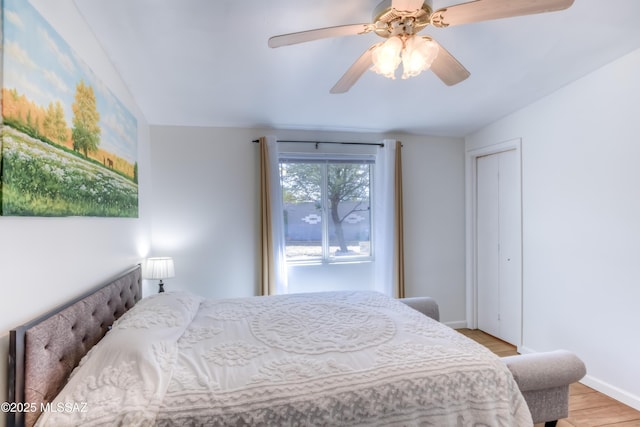 bedroom with ceiling fan, light hardwood / wood-style floors, and a closet