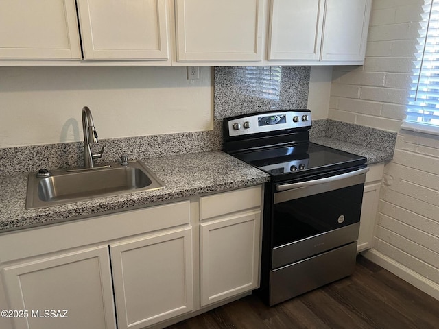 kitchen with dark wood-type flooring, sink, stainless steel range with electric cooktop, white cabinetry, and light stone counters