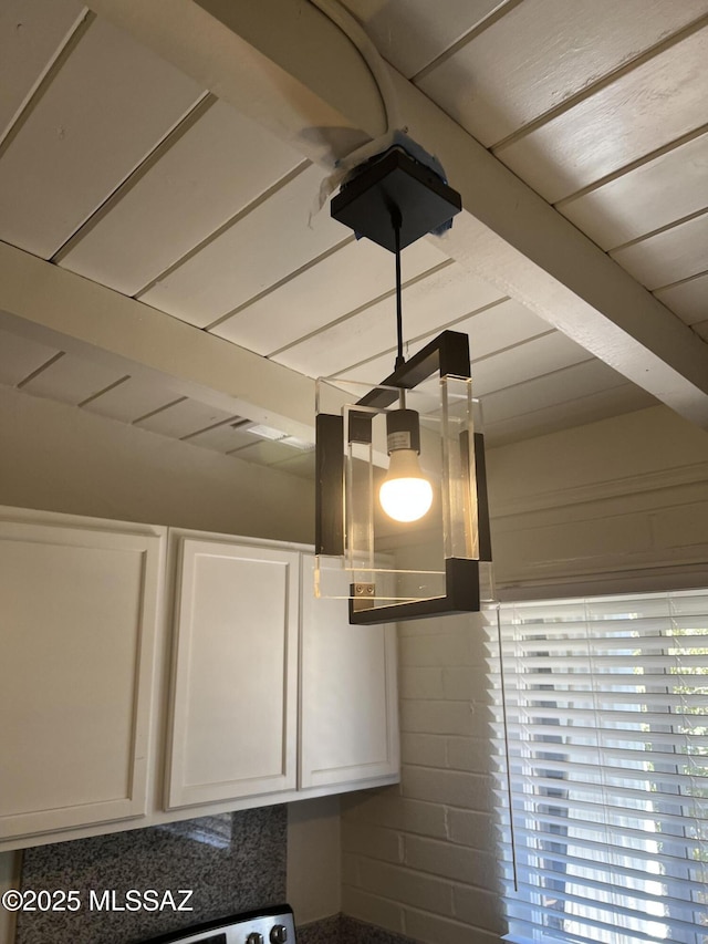 interior details featuring beamed ceiling and white cabinetry