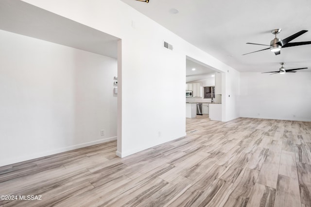 unfurnished living room featuring ceiling fan and light hardwood / wood-style flooring