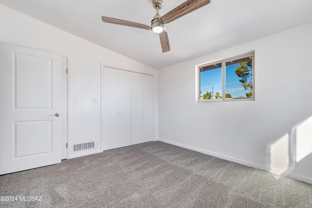 unfurnished bedroom featuring lofted ceiling, a closet, ceiling fan, and carpet flooring