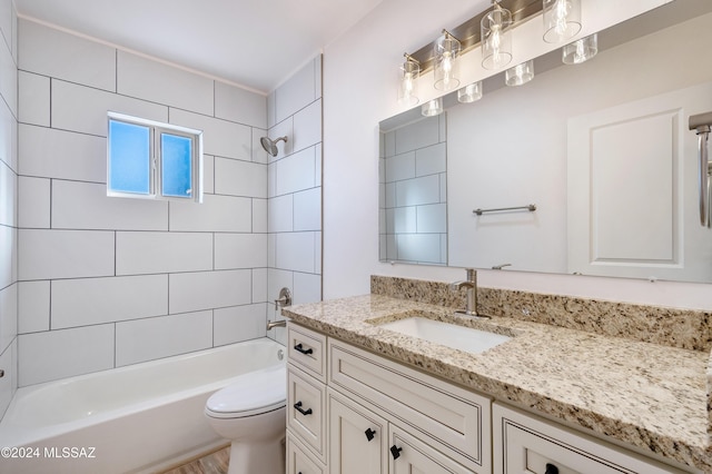 full bathroom with vanity, tiled shower / bath, and toilet