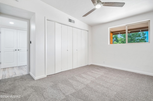 unfurnished bedroom with a closet, ceiling fan, and carpet flooring