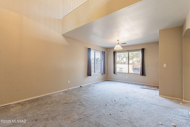 carpeted empty room with a textured ceiling