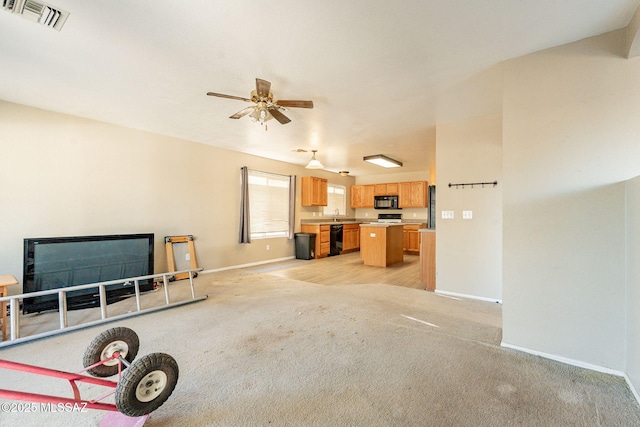 unfurnished living room featuring light carpet and ceiling fan