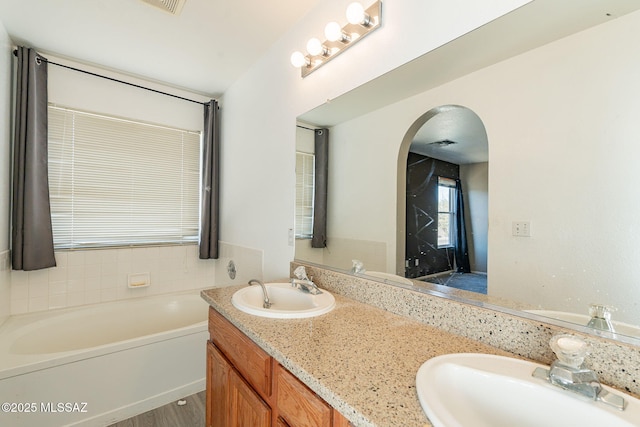 bathroom with vanity and a bath