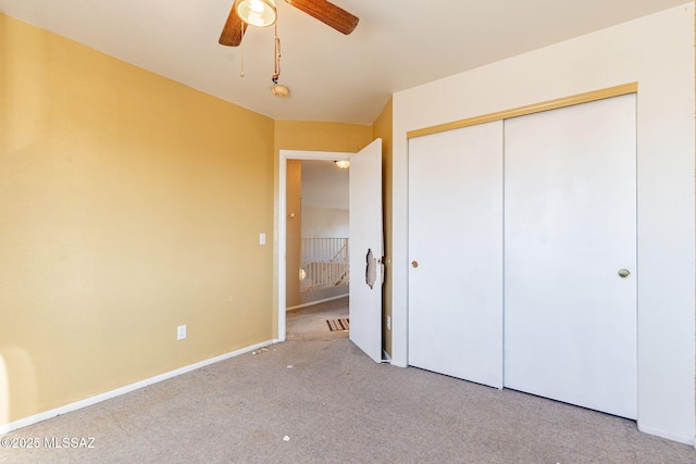 unfurnished bedroom featuring light colored carpet, ceiling fan, and a closet