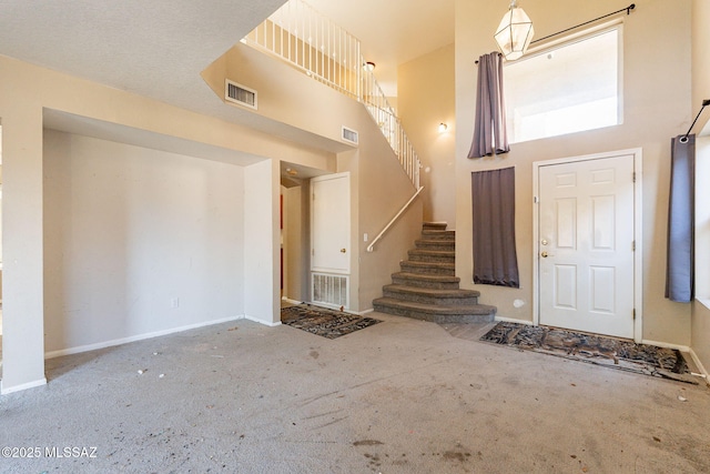 foyer featuring carpet flooring and a high ceiling