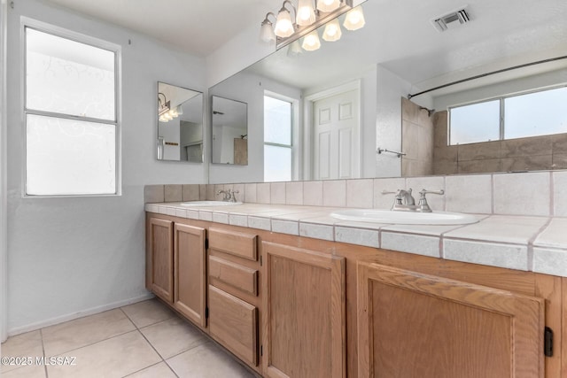 bathroom with vanity, tile patterned flooring, and decorative backsplash