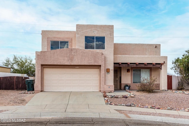 pueblo revival-style home with a garage