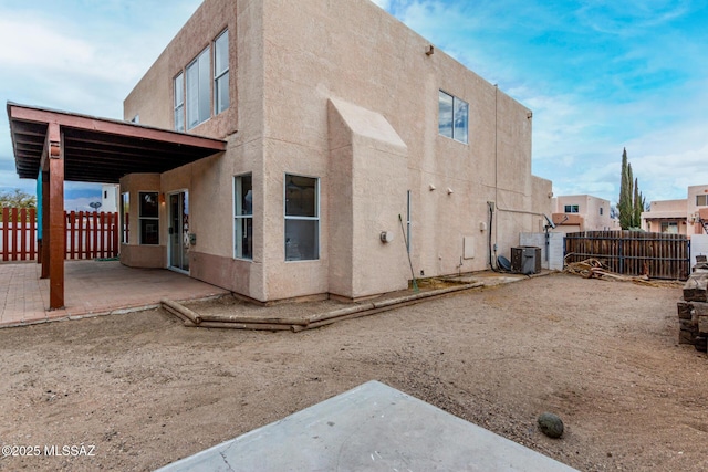 rear view of property with central AC and a patio