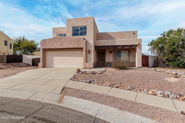 pueblo revival-style home featuring a garage