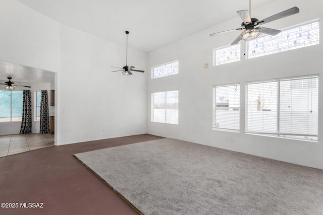 unfurnished living room with a towering ceiling and ceiling fan