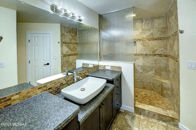 full bathroom with baseboards, walk in shower, vanity, and decorative backsplash