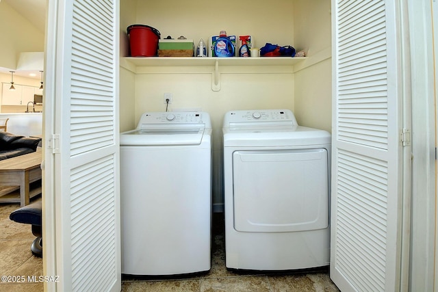 clothes washing area featuring laundry area, washer and clothes dryer, and a sink