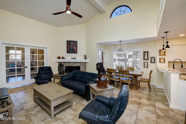 living area featuring ceiling fan, high vaulted ceiling, a fireplace, baseboards, and french doors