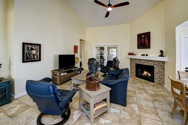 living area with high vaulted ceiling, visible vents, a wealth of natural light, and a stone fireplace