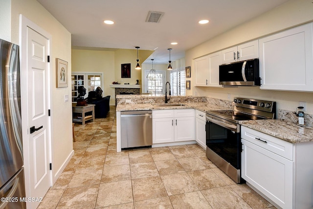 kitchen featuring stainless steel appliances, a peninsula, a sink, and white cabinets