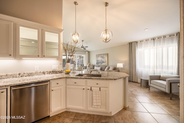 kitchen with sink, decorative light fixtures, vaulted ceiling, dishwasher, and white cabinets