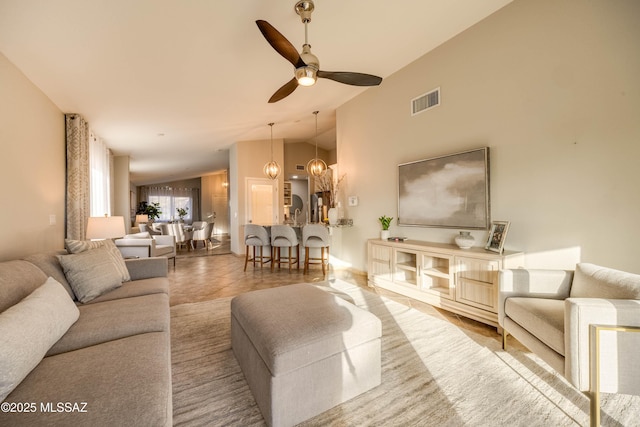 tiled living room with vaulted ceiling and ceiling fan