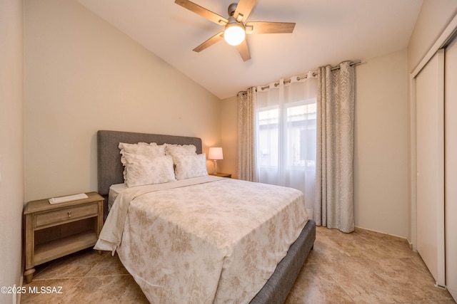 bedroom with ceiling fan, vaulted ceiling, and a closet