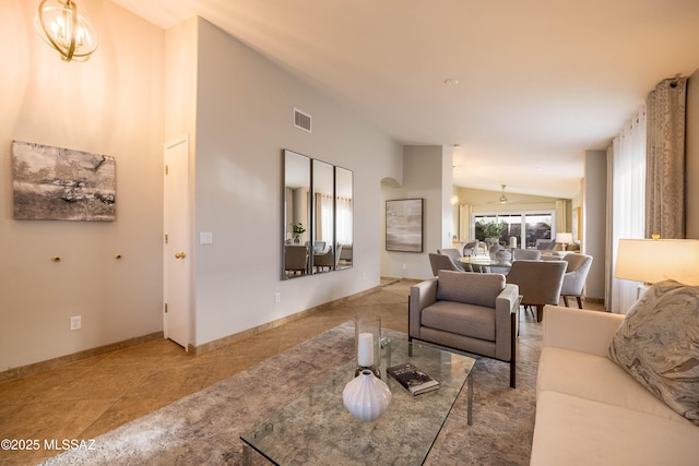 tiled living room with an inviting chandelier and vaulted ceiling