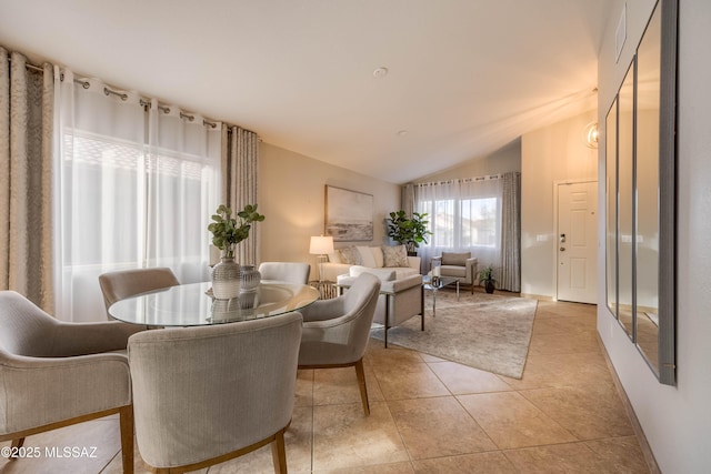 tiled dining room featuring lofted ceiling