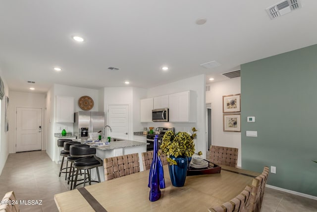 dining space with sink and light tile patterned floors