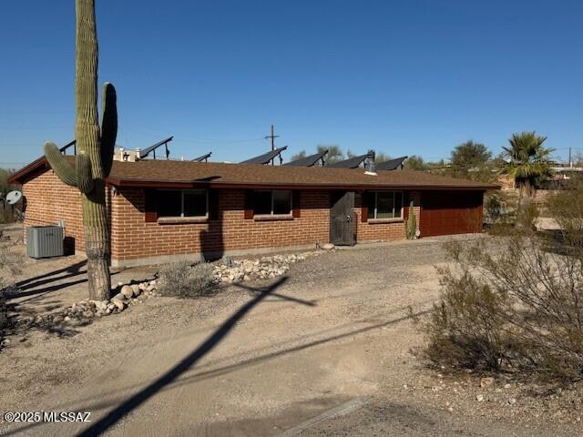 ranch-style home featuring central AC unit