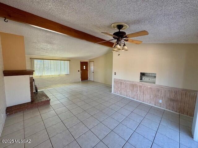 spare room with ceiling fan, light tile patterned floors, and a textured ceiling