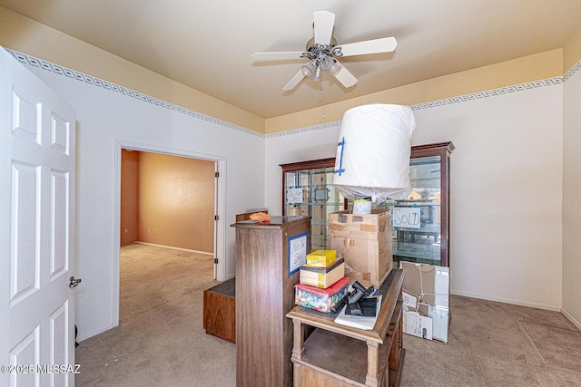 carpeted home office featuring ceiling fan