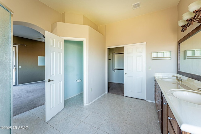 bathroom with tile patterned flooring, vanity, and ceiling fan