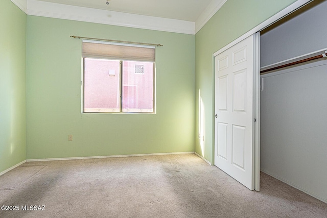 unfurnished bedroom with ornamental molding, light carpet, and a closet