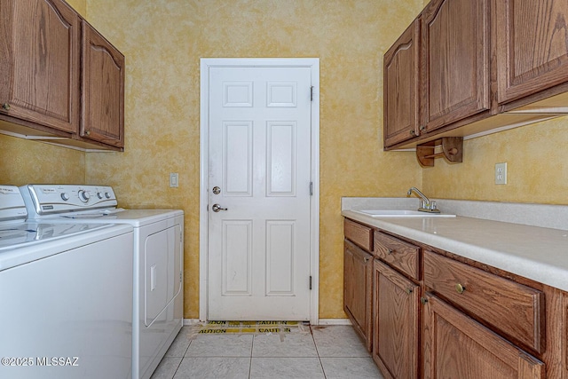 clothes washing area with cabinets, sink, washing machine and dryer, and light tile patterned floors