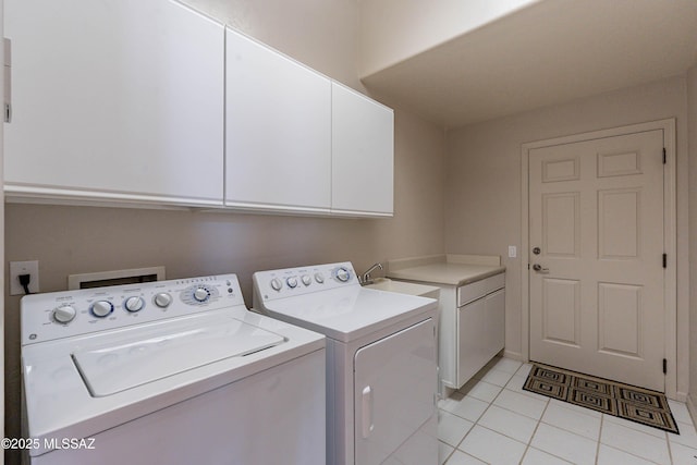 laundry area with cabinets, sink, light tile patterned floors, and washing machine and clothes dryer