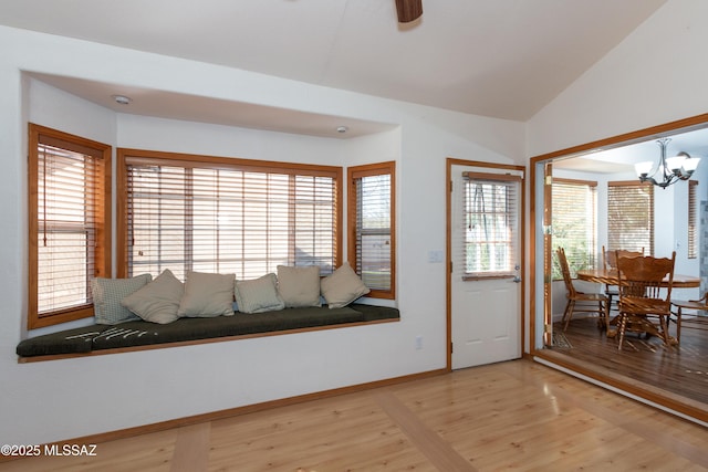 interior space with a chandelier, vaulted ceiling, and light hardwood / wood-style flooring