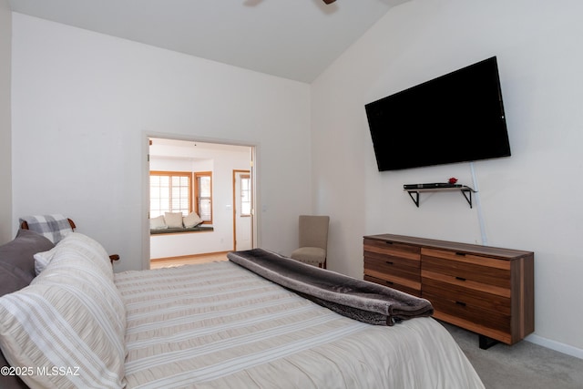 bedroom with lofted ceiling and light colored carpet