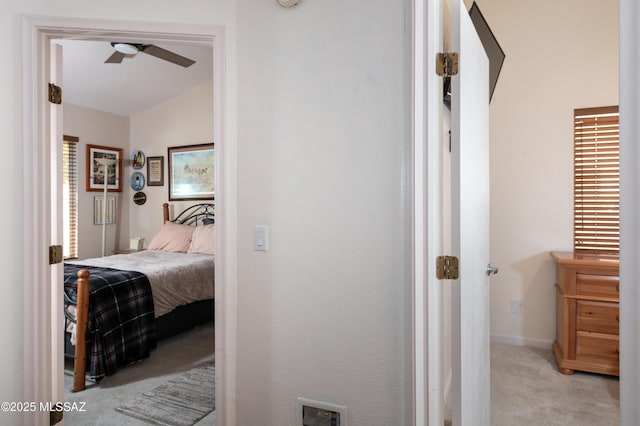 hallway featuring vaulted ceiling and light colored carpet