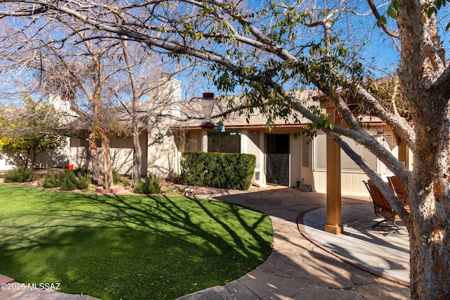 view of front of home with a front yard and a patio