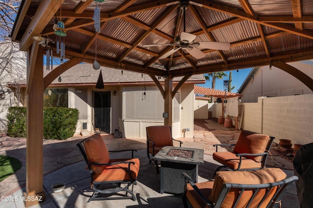 view of patio with a gazebo, ceiling fan, and a fire pit