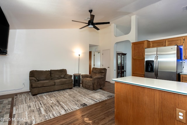 kitchen featuring stainless steel fridge with ice dispenser, dark wood-type flooring, ceiling fan, and vaulted ceiling