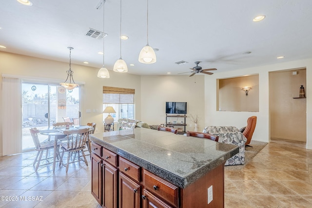 kitchen featuring light tile patterned flooring, a center island, pendant lighting, and ceiling fan