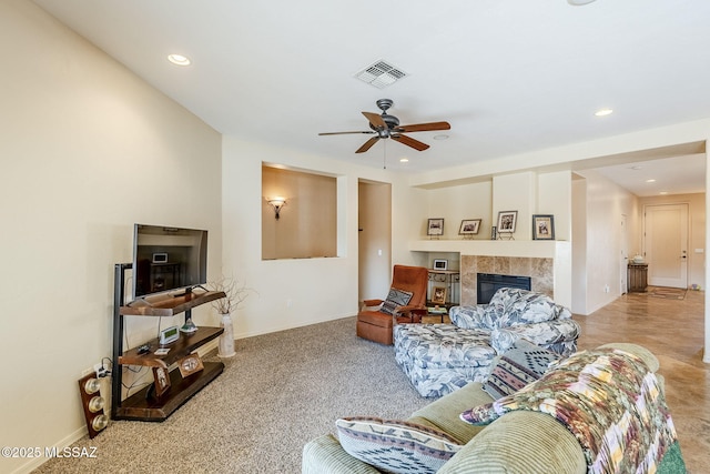 living room featuring ceiling fan and a tile fireplace